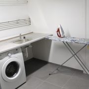 The shared laundry room with a washing machine